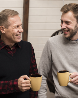 Front View Smiley Father Son Posing While Holding Cups