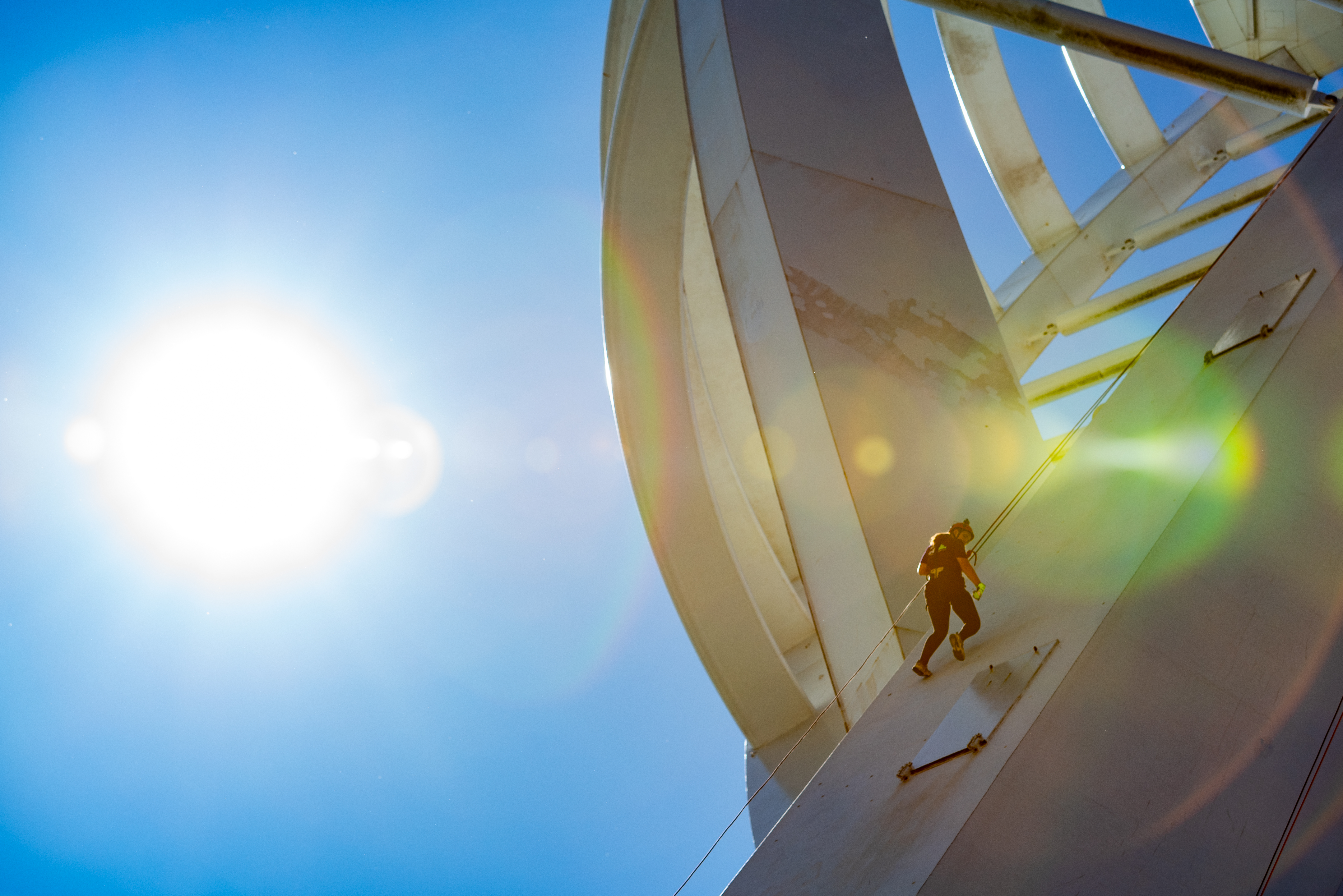 Sun shines behind an abseiler coming down Spinnaker Tower