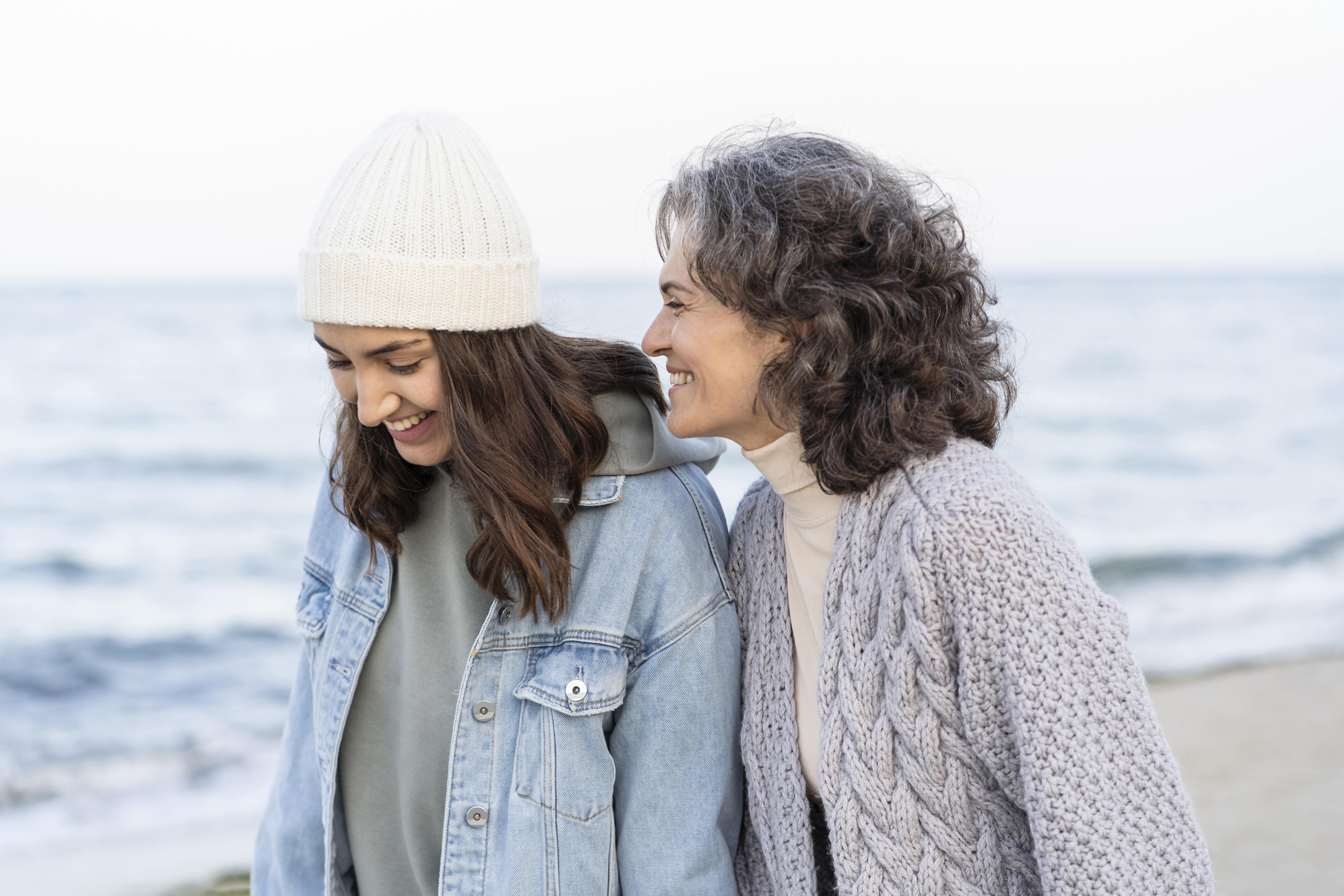 female foster carer and child walk along the sea front